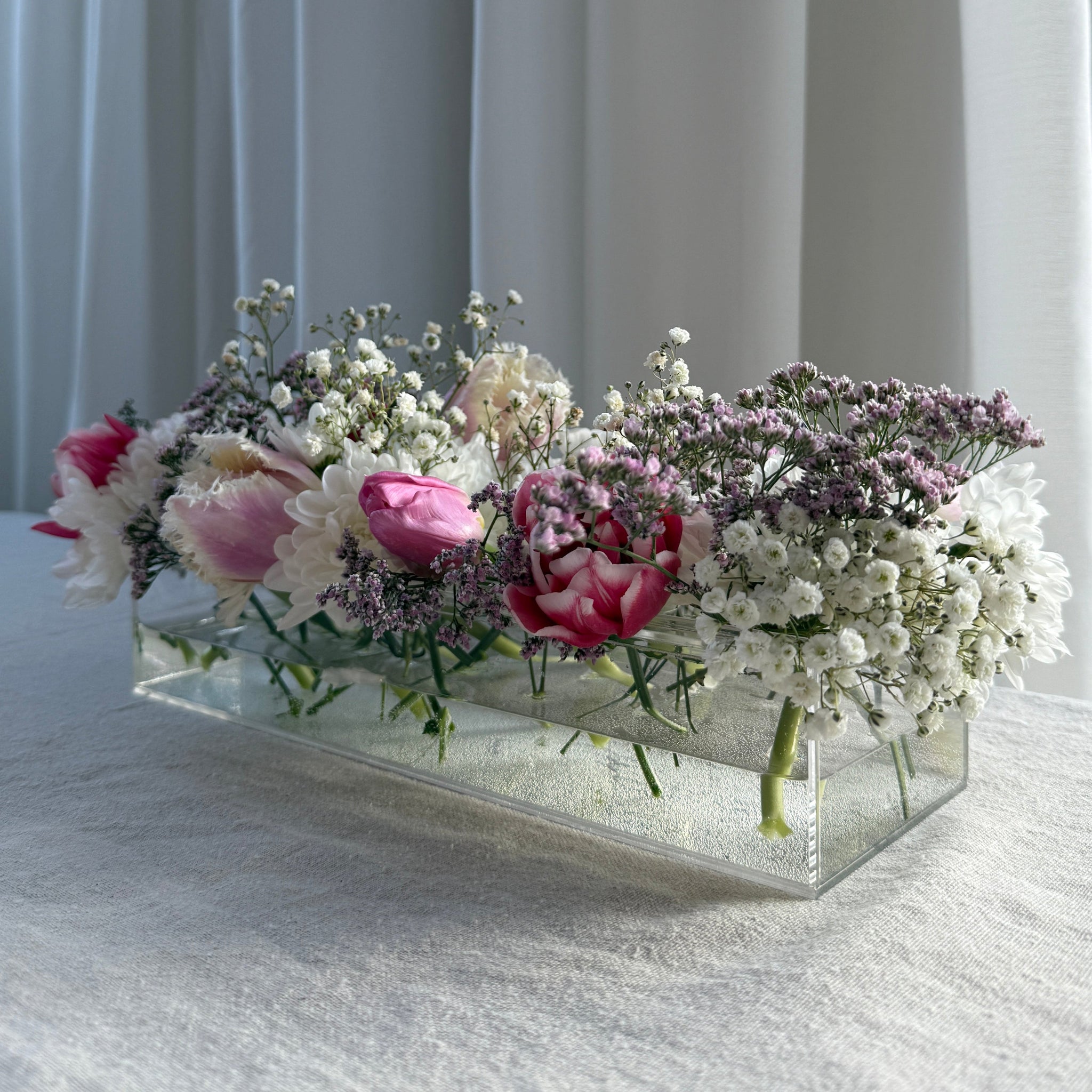 Blomsterarrangemang med vår akrylvas